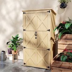 a wooden storage cabinet sitting next to some potted plants