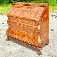 an old wooden music box sitting on the ground