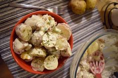 a bowl full of potato salad next to another bowl with potatoes in it