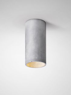 a light that is on the ceiling in a white room with a gray wall behind it