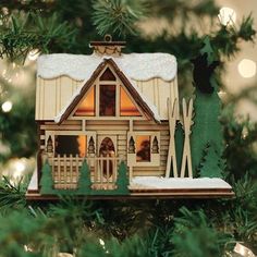 a wooden house ornament hanging from a christmas tree