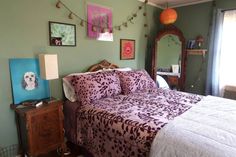 a bed room with a neatly made bed and pictures hanging on the wall above it