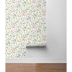 a white wall with flowers on it and a wooden floor in front of the wall