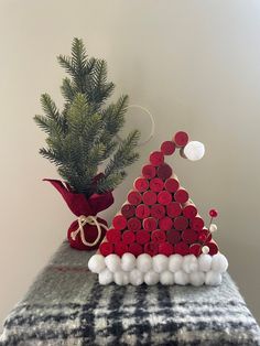 a christmas tree made out of wine corks on top of a table next to a potted plant