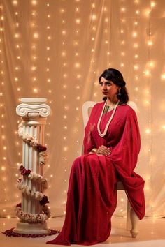 Reminiscent of the Bollywood divas of 1950s, the sarees in this collection aim at re living that timeless & elegant era, that is so close to the timelessness of Mukaish Embroidery. This Wine Coloured Saree is adorned with delicate embroidery of Flight of Pigeons (original Meiraas motif) on palla in a triangle flight pattern, while rest of the saree is covered with stars of Mukaish. NOTE: Mukaish is a Heritage Embroidery done by hand. This embroidery was initially done with Gold & Silver wires ones, but now is done with copper or even brass metal wires polished to gold & silver colour. For this embroidery following steps are taken: 1.)The wires are beaten to a thin thread like consistency first. 2.)A special Mukaish needle uses the beaten wires to make intricate patterns that are block prin Festive Bollywood Pre-draped Saree With Pallu, Traditional Pre-draped Saree With Dori Work For Eid, Navratri Celebration Pre-draped Saree With Zari Work, Dola Silk Chandbali Pre-draped Saree For Diwali, Pre-draped Georgette Saree For Puja And Eid, Traditional Georgette Pre-draped Saree For Celebration, Pre-draped Georgette Saree For Celebration, Floor-length Pre-draped Saree For Diwali, Navratri Pre-draped Saree With Cutdana