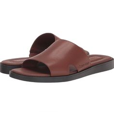 -Effortless And Fashionable, The Calvin Klein Ethan Slide Sandal Is A Wardrobe Essential. The Casual Silhouette Is Perfect To Pair With Jeans Or Shorts. Founded In New York In 1968, The Brand Elevates Everyday Essentials To Globally Iconic Status. -Sole Material: Thermoplastic Rubber -Outer Material: Faux Leather -Closure Type: Slip On -Open Toe Classic Synthetic Slip-on Sandals, Casual Brown Open Heel Slides, Calvin Klein Casual Sandals For Summer, Classic Slip-on Synthetic Sandals, Casual Calvin Klein Sandals For Summer, Calvin Klein Sandals With Removable Insole And Round Toe, Brown Casual Open Heel Slides, Calvin Klein Casual Sandals With Cushioned Footbed, Calvin Klein Open Toe Sandals With Cushioned Footbed