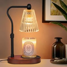 a lit candle sitting on top of a table next to a vase and other items