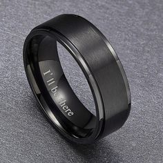 a black ring with the word love engraved on it, sitting on a gray surface