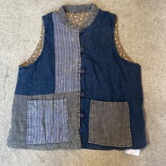 a vest made out of old jeans with patches on the front and back, sitting on carpet