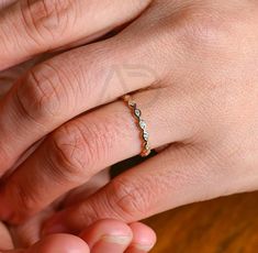 a woman's hand with a diamond ring on her left and a man's right hand