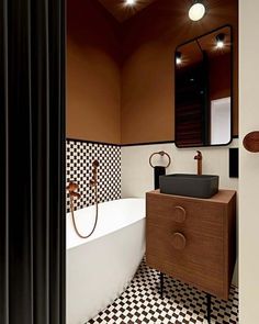 a bathroom with black and white checkered tile on the floor, sink, mirror and bathtub