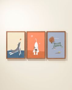 three paintings hang on the wall in front of a white wall and one has an animal