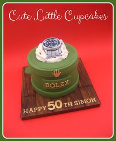 a birthday cake with a rolex watch on top and happy 50th sign in the middle