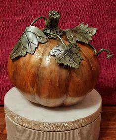 a metal pumpkin sitting on top of a box