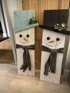 two snowmen made out of pallets with hats and scarves