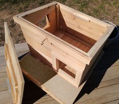 a wooden box sitting on top of a wooden floor next to a bucket and shovel