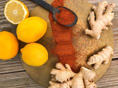 lemons and ginger on a cutting board with spices