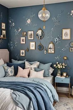 a bedroom with blue walls and pictures on the wall above the bed, along with other decor items