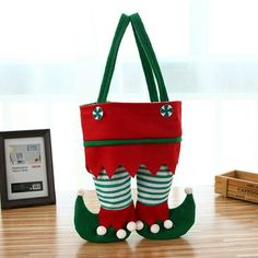 a red and green handbag sitting on top of a wooden table next to a framed photo