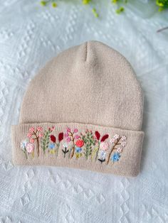 a white hat with flowers embroidered on it