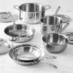 stainless steel pots and pans on a white table