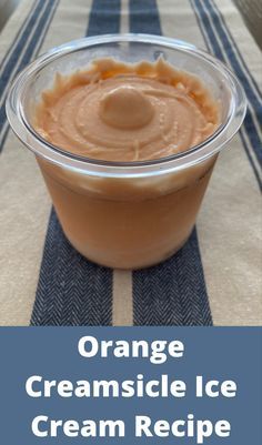 an orange creamsice ice cream recipe in a plastic container on a blue and white tablecloth