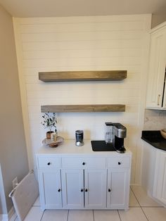 a kitchen with white cabinets and black counter tops, along with shelves above the stove