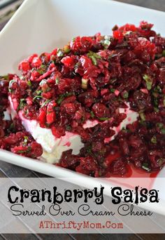 cranberry salsa served over cream cheese in a white dish on a wooden table