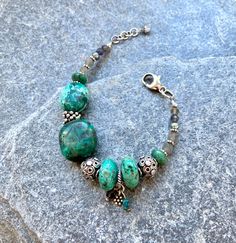 "WELCOME TO L TRIFILIO JEWELRY!  Handcrafted artisan jewelry, made in Vermont. From Classic to Funky. Buy 2 or more pieces and get 20% off your order!  Use Promo Code: 20OFF2ORMORE  This is a one of a kind, unique, handcrafted bracelet with chunky African Turquoise, Chrysocolla, Labradorite, LARGE Bali Sterling Silver Beads, Freshwater Pearls, and a Large, easy to hold 15mm Sterling Silver lobster clasp! Loaded with sterling silver. Made with high quality 49 strand beading wire. Throat Chakra - I Speak ...  Color: Bright blue  Supports: Clear communication, expression, truth   Heart Chakra - I Love. ...  color: green Supports: love, self love, compassion, acceptance DIMENSIONS: For wrists from about 6 1/2- 7 1/2. Length: 7 3/4\" total including the large sterling lobster clasp and 1/2\" ex Green Bohemian Beaded Bracelets With Stones, Bohemian Green Beaded Bracelets With Stones, Bohemian Green Beaded Bracelets, Bohemian Beaded Bracelets In Turquoise Chrysocolla, Bali Silver, Clear Communication, African Turquoise, Handcrafted Bracelets, Handcrafted Artisan Jewelry