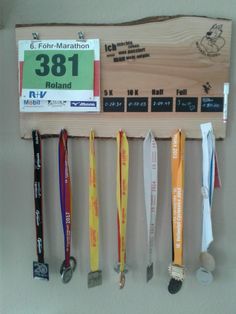 a number of medals are hanging on a wooden plaque that is attached to the wall