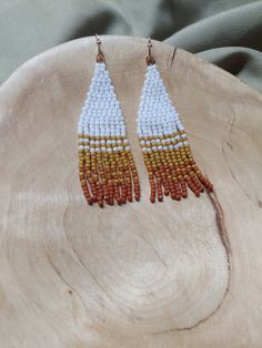 Handcrafted seed bead danglers; modeled after the snow dusted red rock in Sedona. White, mustard yellow, and rust with silver findings. Each pair is made with over 200 glass beads and woven with strong, braided thread. Approximately 2.25 inches long. Please care for your earrings, store them flat or hung when not being worn. Artisan White Dangling Beads, Artisan White Beaded Earrings, White Artisan Beaded Earrings, Artisan White Beaded Earrings With Tiny Beads, Artisan White Beaded Earrings With Colorful Beads, Artisan White Beaded Earrings With Dangling Beads, White Artisan Beaded Earrings With Colorful Beads, Orange Dangling Beads For Jewelry Making, Artisan White Earrings With Tiny Beads