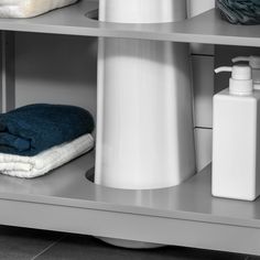 two shelves with towels, bottles and soap dispensers