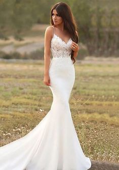 a woman in a white wedding dress standing on a wooden plank with her hands behind her back