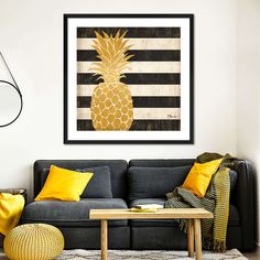 a living room with a couch, coffee table and pineapple painting on the wall