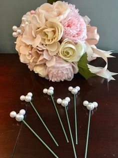 a bouquet of flowers sitting on top of a wooden table next to some white and pink flowers