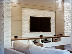 a large flat screen tv mounted to the side of a wall in a living room