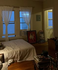 a bed sitting in a bedroom next to two windows