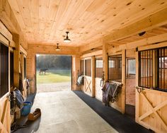 the inside of a horse barn with doors open