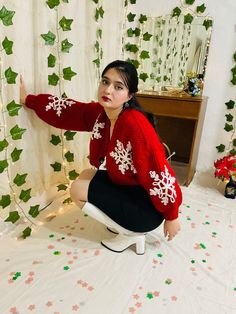 a woman kneeling on a chair in front of a christmas backdrop