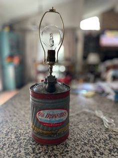 a light bulb is sitting on top of a can with a lamp attached to it