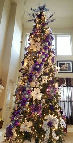 a decorated christmas tree with purple and silver decorations