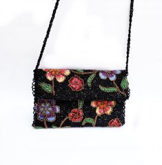 Floral Women's Hand-Beaded Clutch with Beaded Braid Chain Purse Fashion Evening Bag * Item: Handmade *        Shape: Envelope *        Strap: 60cm/24inches long shoulder Braided Bead Strap *        Main Color: Shine Black *        Other Colors: Multi-Colors of Flowers in which Green, Red, Maroon, Orange, Blue, Purple, Yellow, Black, and Bronze * Length: 26cm/10inches; Width: 15cm/6inches * Materials: Beads, Fabric, Glass Beads, Zip, Silk, and Magnetic Snap Fastener I designed the pattern and create this clutch for women. A handmade item is imperfect as it may have little invisible imperfections. The Clutch will be embroidered to order, so small changes are possible, and it will not be noticeable to you.  A unique gift for an anniversary or any other occasion is a great idea to choose a pur Multicolor Evening Bag With Chain Strap, Multicolor Beaded Bag For Evening, Multicolor Chain Strap Evening Bag, Handmade Purple Bag, Beaded Rectangular Shoulder Bag For Events, Rectangular Beaded Shoulder Bag For Events, Evening Multicolor Shoulder Bag With Handwork, Beads Fabric, Purse Wedding