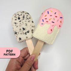 two ice cream popsicles with sprinkles on them, one is pink and the other is white