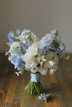 a bouquet of white and blue flowers in a vase