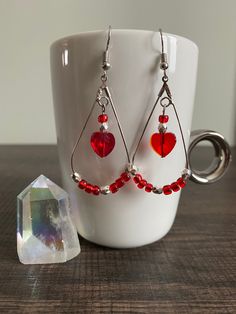 Adorable handmade teardrop earrings made with red glass 6/0 seed beads and silver faceted spacer beads. Featuring glass red heart beads dangling at the center. Perfect for Valentines Day and very lightweight!  * All materials were cleaned and sanitized prior to use and kept in a clean smoke free environment. Comes packaged in a mesh drawstring bag. Valentine Earrings, Valentines Earrings, Handmade Wire Jewelry, Handmade Wire, Heart Beads, Beaded Dangles, Red Glass, Teardrop Earrings, Spacer Beads