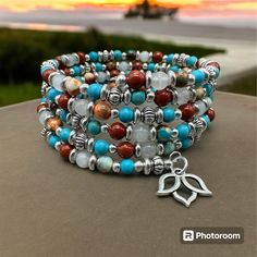 Tiny round genuine Red Jasper, White Jade, Ocean Jade, and Blue Magnesite beads, along with bright silver accents are threaded onto thin stainless steel memory wire to create this beautiful bracelet featuring a dainty silver lotus flower charm. Because of the use of memory wire, this piece will fit most wrists comfortably.  Only high-quality genuine stones are used in every handmade design.  Red Jasper: provides energy and passion; promotes concentration and focus White Jade: promotes inner peace and calm; provides balance and harmony Ocean Jade: releases stress and anxiety; encourages optimism and joy  Blue Magnesite: promotes imagination and creativity; encourages love and opens the Heart chakra Bracelets Patterns, Glamour Nails, Diy Bracelets Patterns, Beach Wrap, Beaded Cuff Bracelet