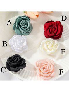 four different colored roses on a white plate