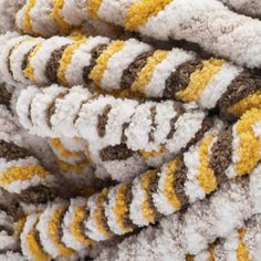 a pile of white, brown and yellow blankets