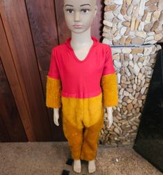 a mannequin is dressed in winnie the pooh costume and stands next to a fireplace