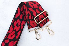 Adjustable black and red animal print purse strap. Pair this with your favorite crossbody messenger bag, purse, tote bag or handbag.  This strap is also the perfect addition for game day or to show off your school spirit. Adjustable length 30 - 54 inches (including clasps) 2 inches wide Gold hardware Design is shown on both sides of the strap Red Rectangular Bag Strap For Everyday Use, Red Adjustable Bag Strap For Everyday Use, Red Adjustable Strap For Bag, Red Rectangular Bag Strap For Daily Use, Red Bags With Adjustable Straps For Daily Use, Red Crossbody Bag Strap For Everyday Use, Red Bag With Adjustable Straps For Everyday Use, Red Detachable Bag Strap For Daily Use, Red Crossbody Bag With Strap